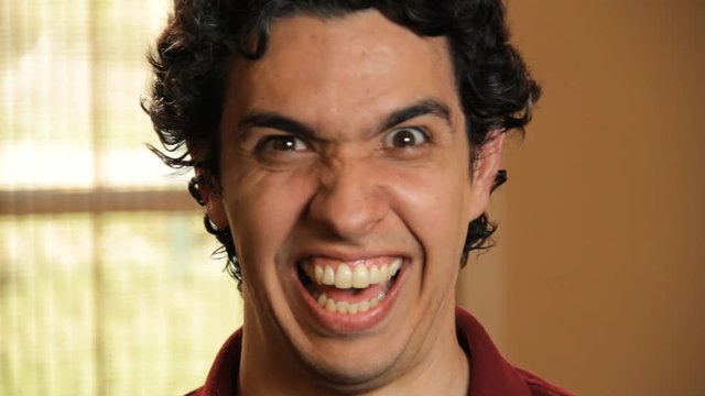 Close up, man laughs maniacally
