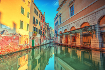 Historical streets in water canal filled with green water, Venice, Italy