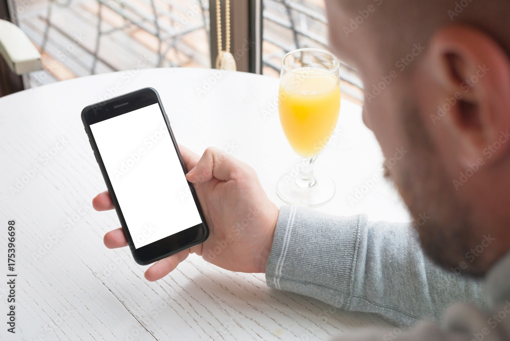 Poster user hold mobile phone with blank screen for mockup. app presentation template. coffee shop in backg