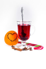 Stack of hot mulled wine with apples and oranges, cloves and vanilla sticks on a white background. Hot Christmas drink.