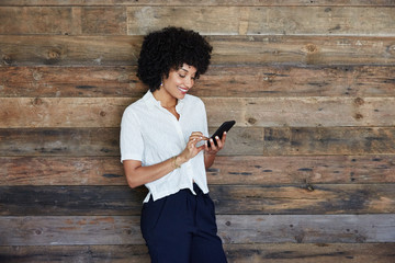 Millennial businesswoman looking at phone in office