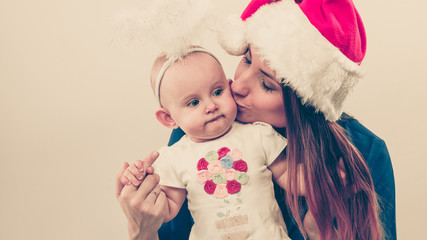 Mother wearing santa hat holding baby