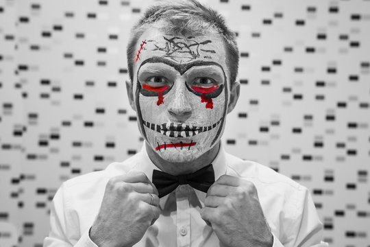 Halloween face art. Portrait of man on halloween party. A young guy dresses up for Halloween.