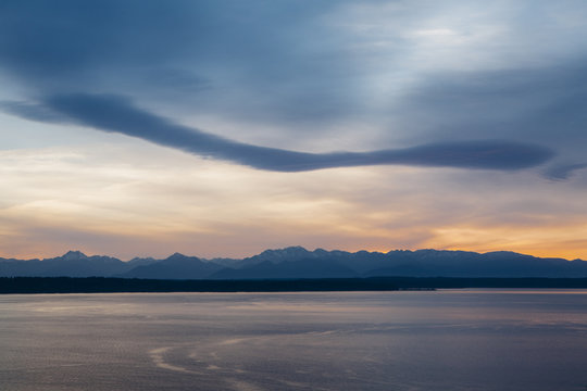 Dramatic sky and clouds over Olympic Mountains at dusk