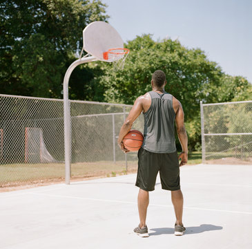 Fit African-American starting at the hoop on a basketball court