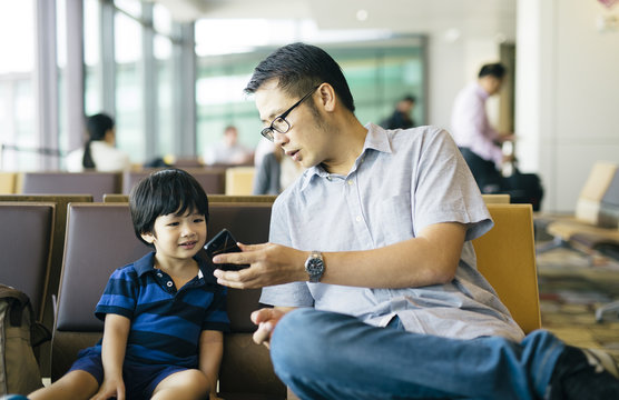 Toddler speaking to grandparents on the phone at airport