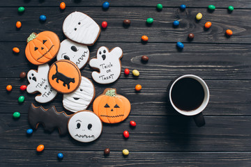 A cup of coffee with colors candy and scary gingerbreads on the Halloween.