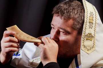 Jewish man blowing the Shofar horn of Rosh Hashanah New Year