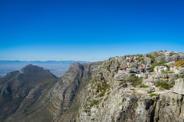 Fototapeta premium People viewing Devil's Peak and the Saddle from Table Mountain, Cape Town