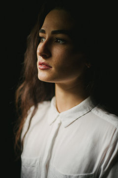 Pretty woman in white button up shirt, septum piercing and long dark hair