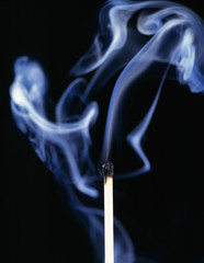 Single smoking match on black background