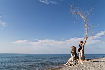 Ragazza con paesaggio marino e albero