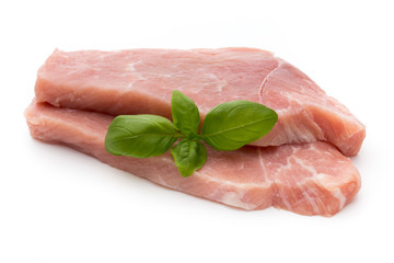 Fresh pork fillet with basil on a white background.