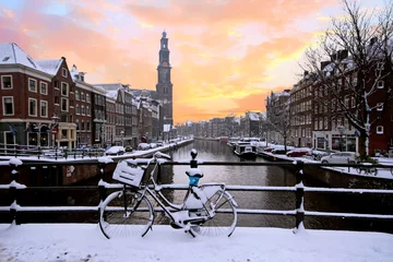 Fototapeten Amsterdam mit Schnee bedeckt mit der Westerkerk im Winter in den Niederlanden bei Sonnenuntergang © Nataraj