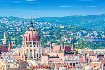 Travel and european tourism concept. Parliament and buda side panorama of Budapest in Hungary during summer sunny day with blue sky and clouds. View from Saint Istvan's basil.