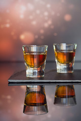 Cognac or liqueur, coffee beans and spices on a glass table.