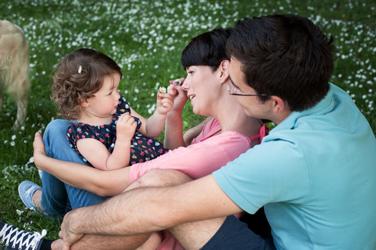 Family cuddling on a field