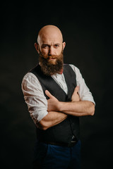 portrait of an adult stylish bearded man on a black background looking at the camera