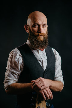 portrait of an adult stylish bearded man on a black background looking at the camera