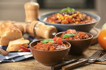 Bowls with delicious chili con carne on table