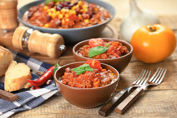 Bowls with delicious chili con carne on table