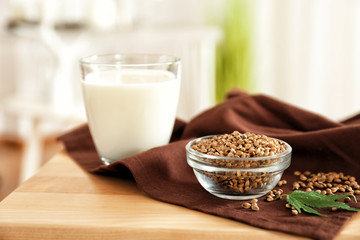 Seeds in bowl and glass with hemp milk on table