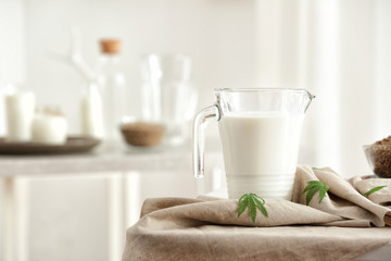 Jug with hemp milk on table