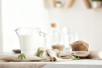 Jug with hemp milk on table