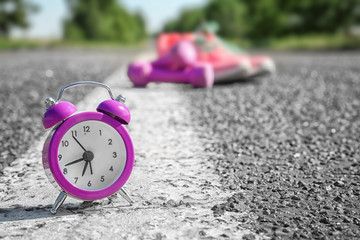 Alarm clock on rural road. Morning routine concept