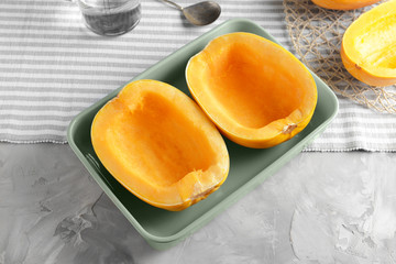 Baking dish with cut spaghetti squash on grey background