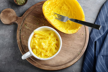 Cup with flesh of spaghetti squash on wooden board