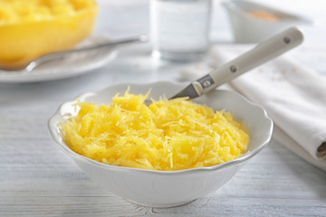 Bowl with flesh of spaghetti squash on wooden background