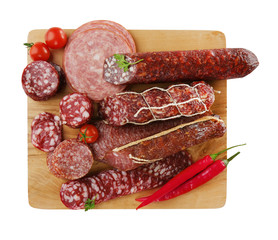 Assortment of sausages on wooden board, isolated on white