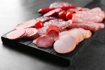 Delicious sliced sausages on wooden board