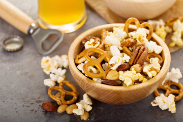 Homemade trail or snack mix with popcorn, pretzels and nuts with beer