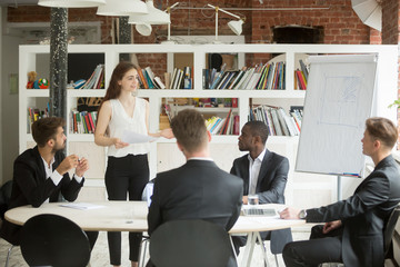 Female executive holding documents, coaching group of corporate employees at briefing. Lady boss...