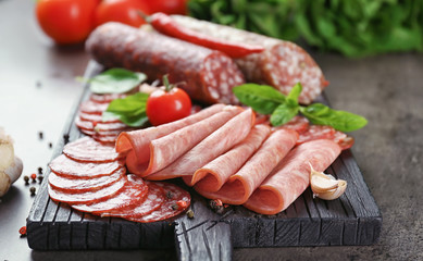 Delicious sliced sausages on wooden board