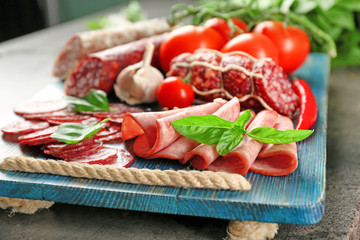 Delicious sliced sausages on wooden board