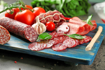 Delicious sliced sausages on wooden board