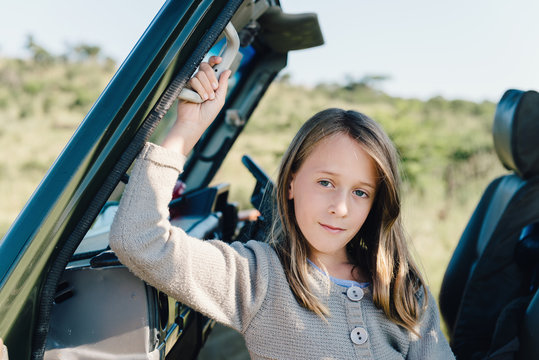 young girl in safari truck, looking to camera