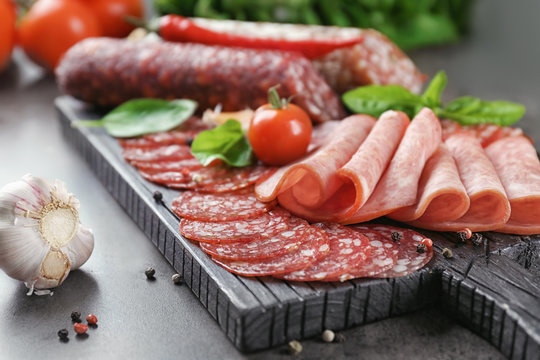 Delicious sliced sausages on wooden board