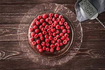 Tasty chocolate cake with raspberries on table