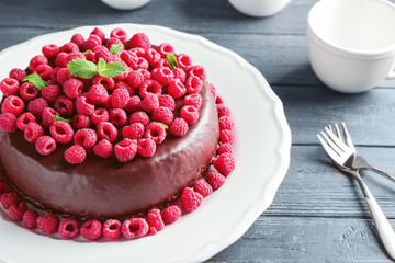 Tasty chocolate cake with raspberries on table