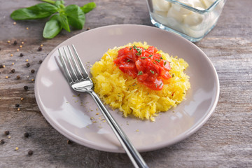 Plate with tasty spaghetti squash on table