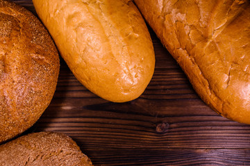Different loafs of bread on wooden table. Top view