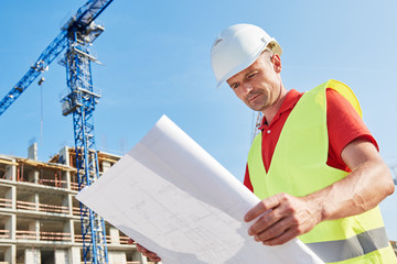 construction worker with blueprint at building area