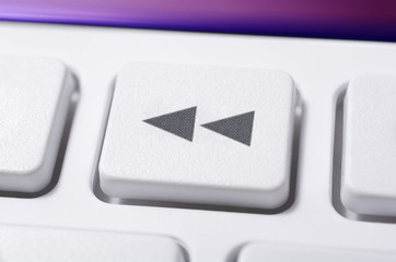 Close Up Of A White Rewind Button Of A White Remote Control For A Hifi Stereo Audio System