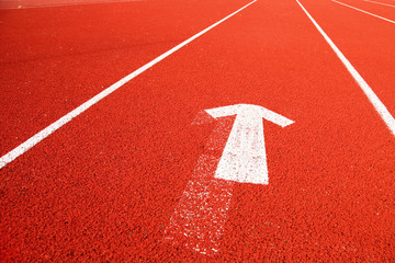 Closeup of the running tartan track with arrow symbol.