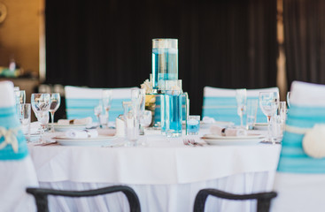 The beautiful wedding hall decorated with a decor in gentle pastel tones from compositions of fresh flowers. Wedding decoration in blue, sea color.