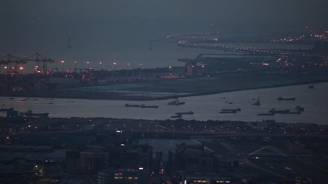 West port - shekou port in shenzhen; ships sailing at sea, cars crossing water bay at bridge at evening